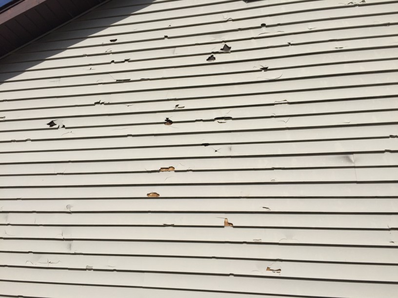 storm-caused-hail-damage-to-vinyl-siding-on-a-house_t20_Joa7yo home siding damaged by hail