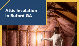 Two workers are in a well-insulated attic space, which is filled with pink fiberglass insulation between wooden studs. One worker, wearing a respirator, holds a bright work light, illuminating the insulated wall. The image features a badge blue and canary yellow overlay with the title "Attic Insulation in Buford GA" in white text.